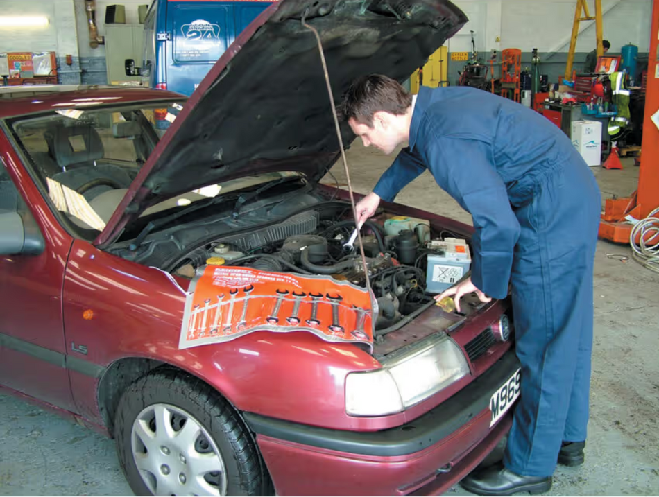 Workshop technician using Kennedy 11pc Metric Open End Spanner Set 6-32mm for car inspection and maintenance.